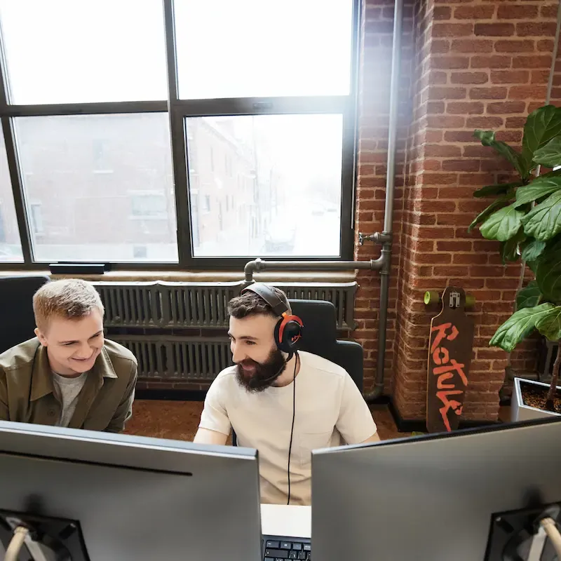 Deux hommes travaillant à leur bureau à deux écrans